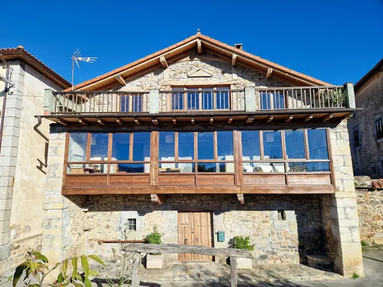 South elevation of Casa de Aja with glazed mirador and upper wooden balcony